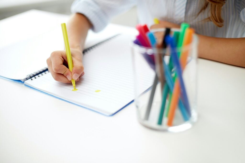 girl drawing with felt-tip pen in notebook
